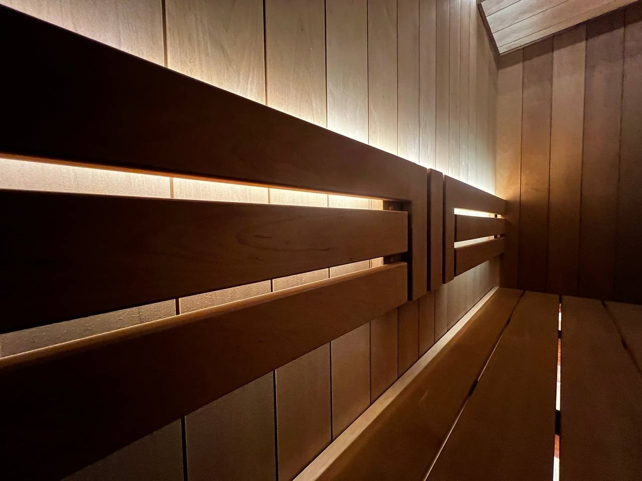 Сауна в Рощино на базе электрокаменки с парогенератором Harvia Virta выполнена из термоольхи с интеграцией световых линий из можжевельника. SaunaTopMasters