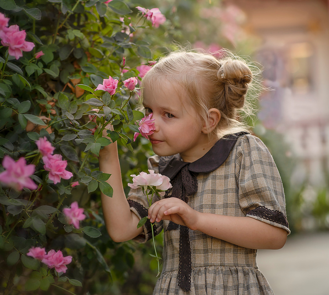 Маленькая Алиса нюхает розы