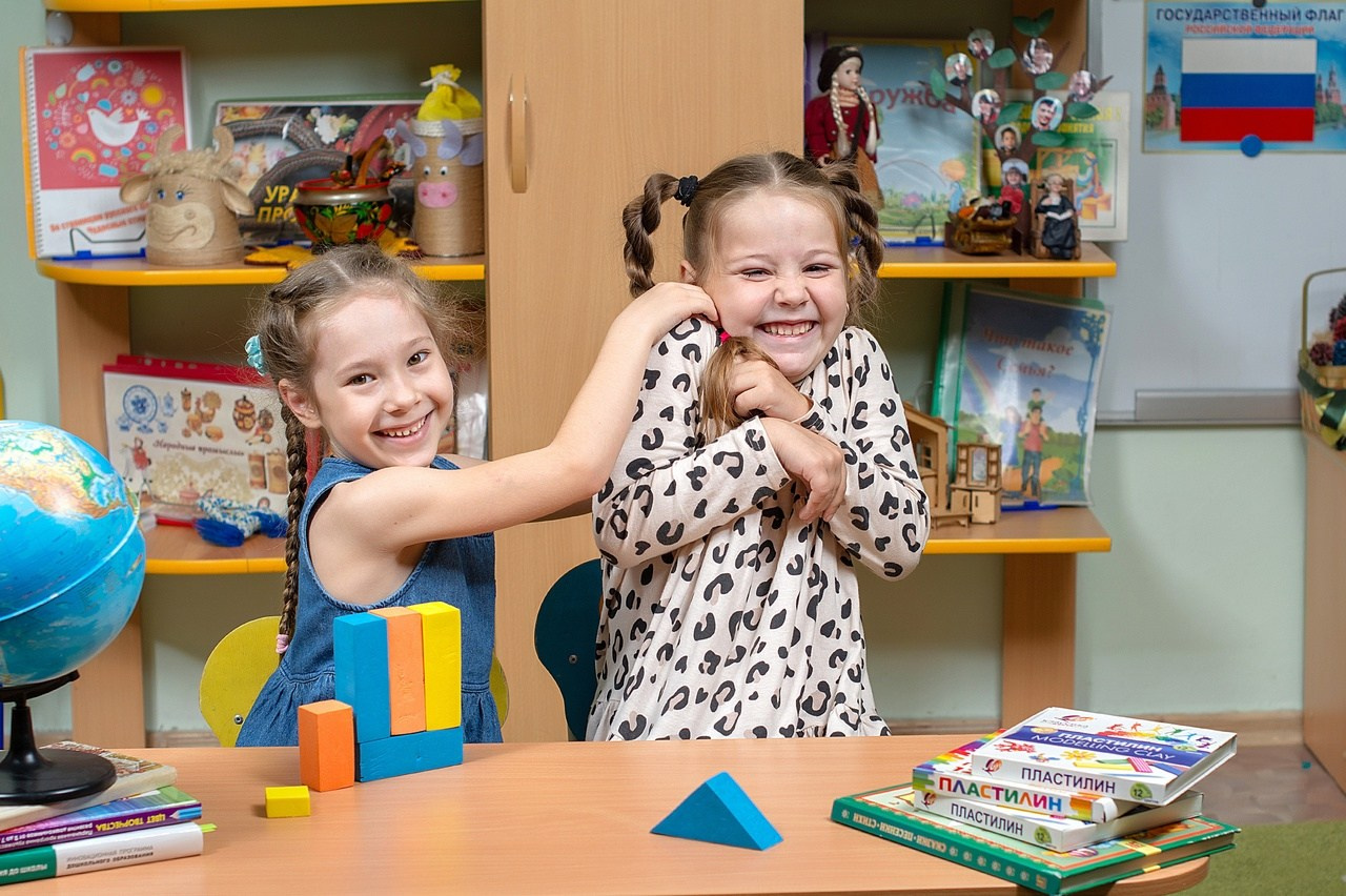 Дети дурачатся и веселятся на фотосессии в детском саду в выпускной группе.