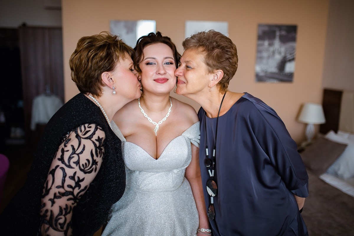 Родные целуют невесту в щёки