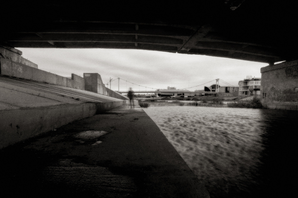 Под мостом не в фокусе фигура человека.