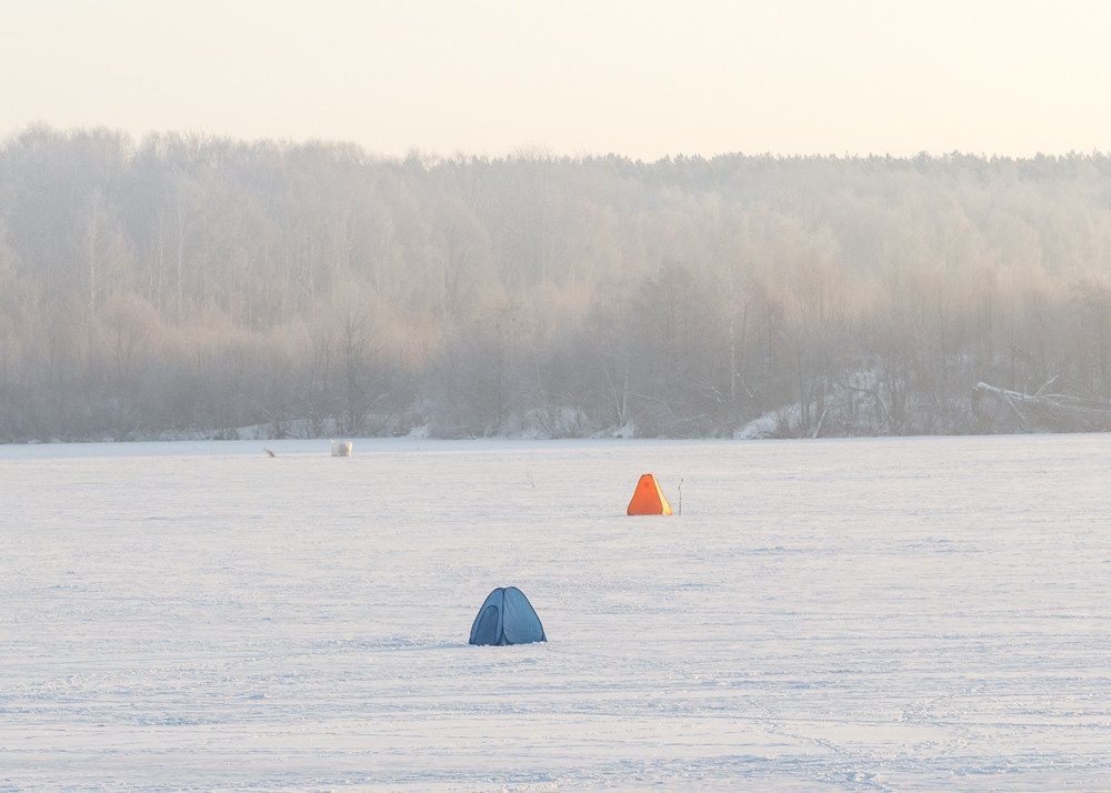 Три палатки рыбаков на льду реки