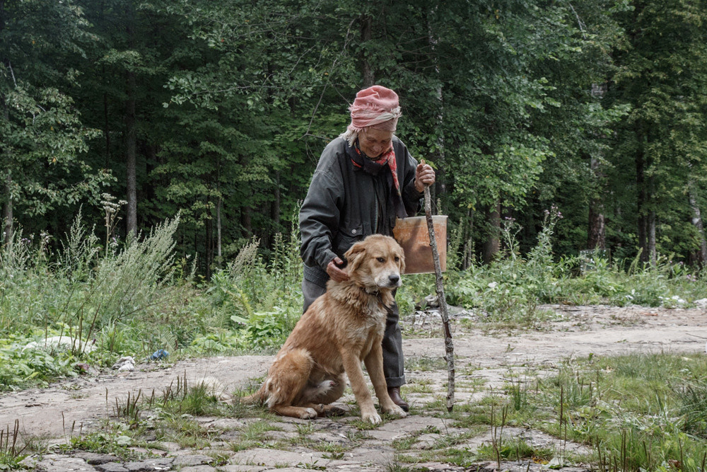 Пожилая женщина в лесу с собакой