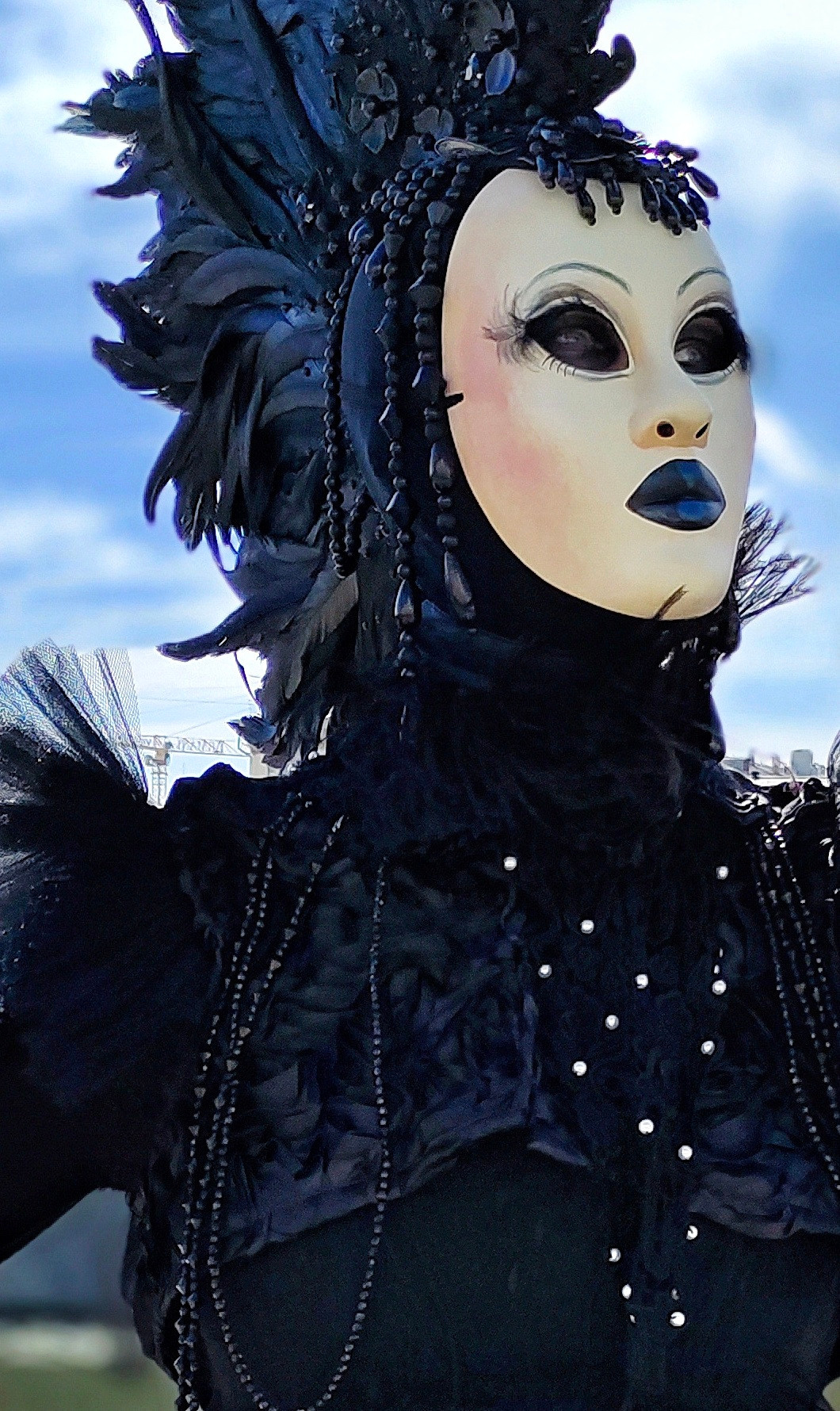 Красивая маска мима артиста в шапке ирокез смотрит вдаль.