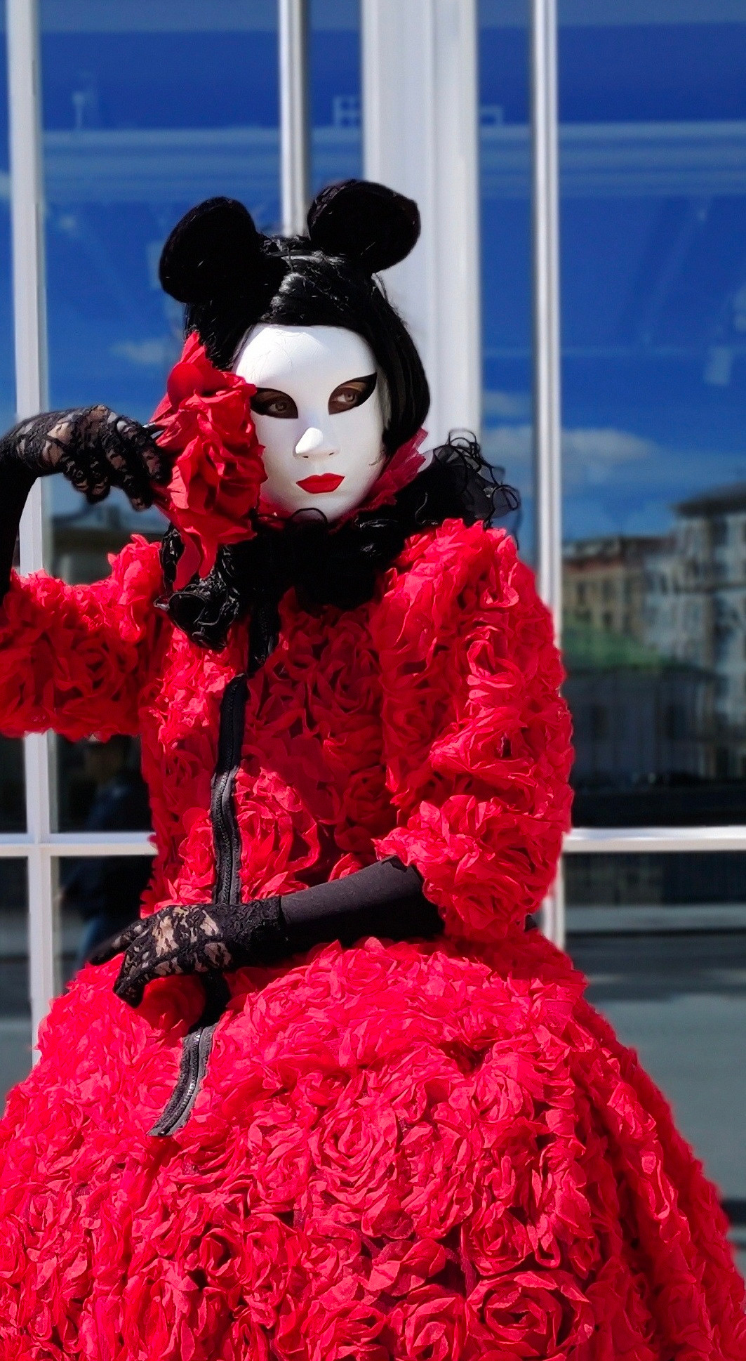 Мышка мим в красном платье позирует фотографу на фотосессии для фотокниги молодым.