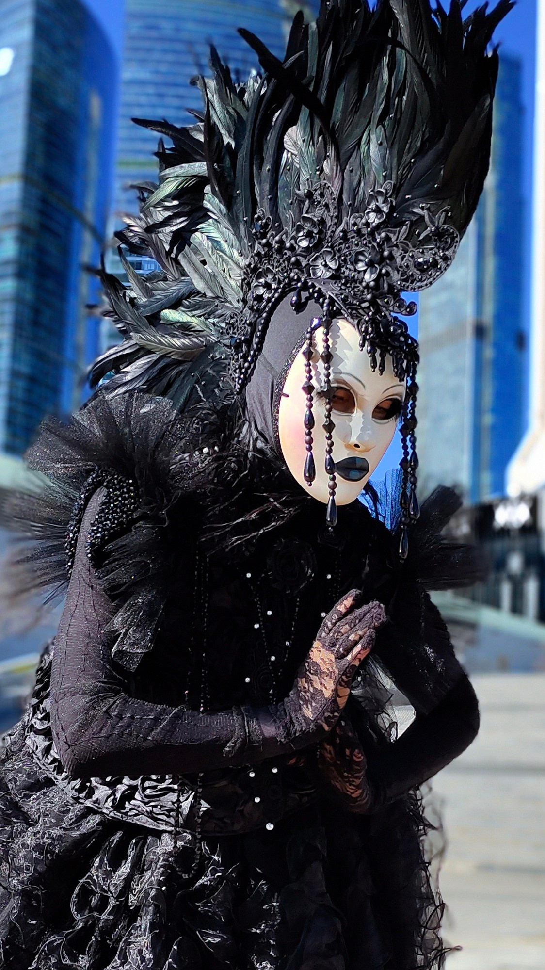 Мим Ворона сложила руки в молитве, позируя фотографу.