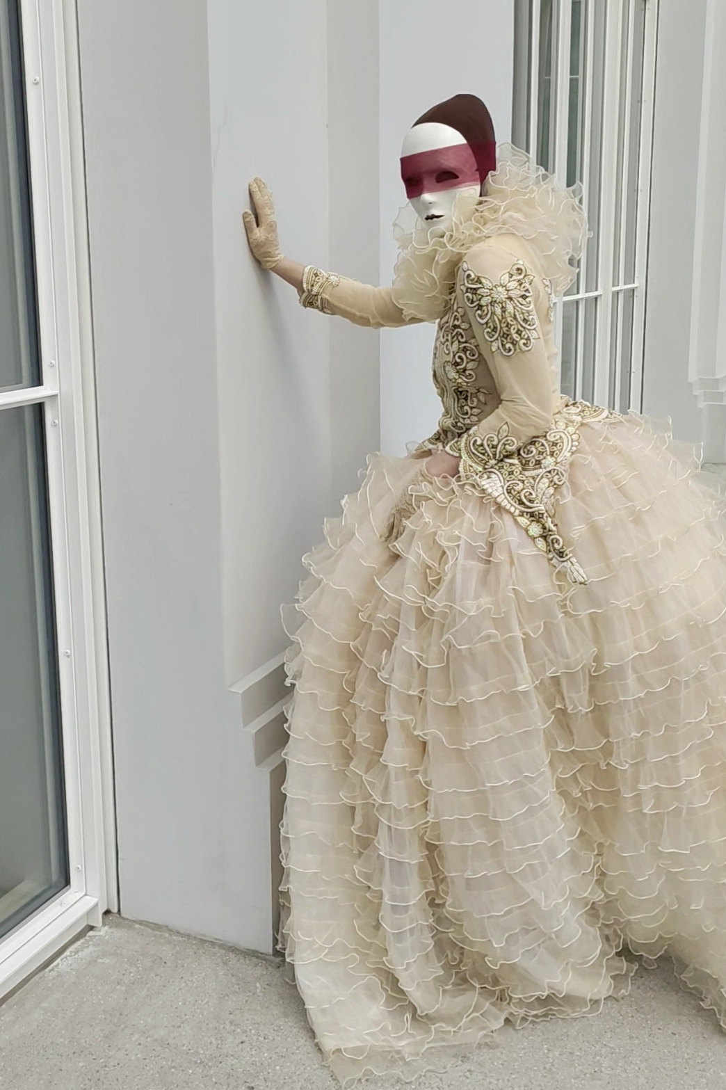 Мим светлая Пешка стоит в ожидании гостей у окна ресторана.