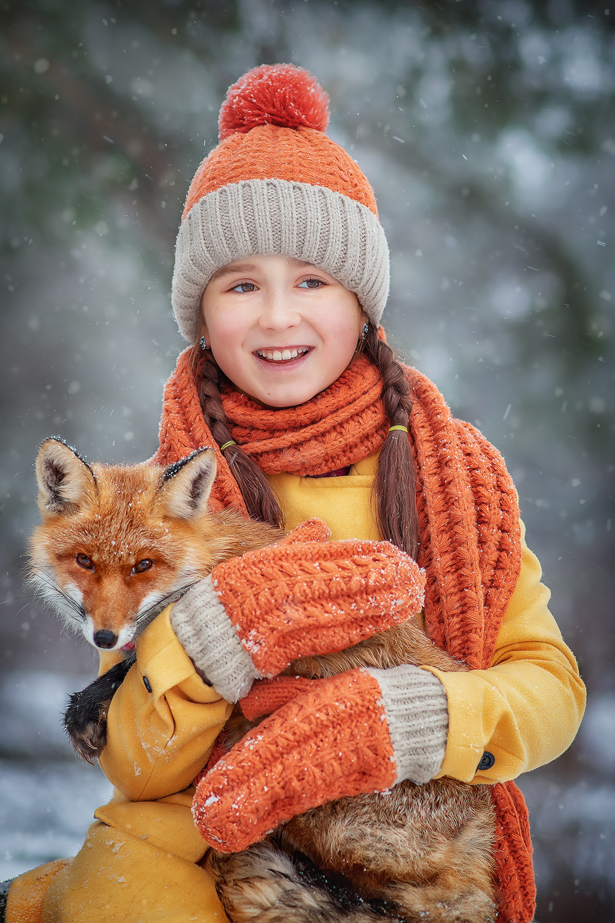 Довольная девочка в желтом пальто держит на руках лису.