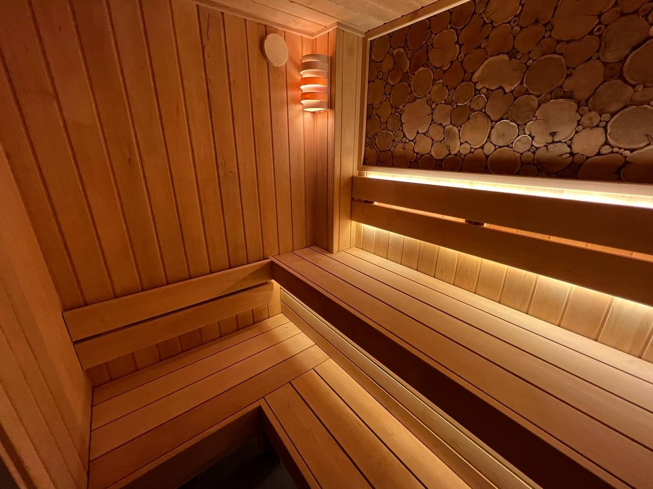 Уютная сауна на Петроградке из белорусской ольхи с можжевеловым панно, винтажными светильниками и паром от Harvia Cilindro. SaunaTopMasters