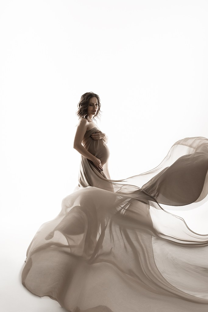 фотосессия беременной в фотостудии на светлом фоне в красивом разлетающемся платье, фотография беременности, фотосессия беременных, портрет беременной
