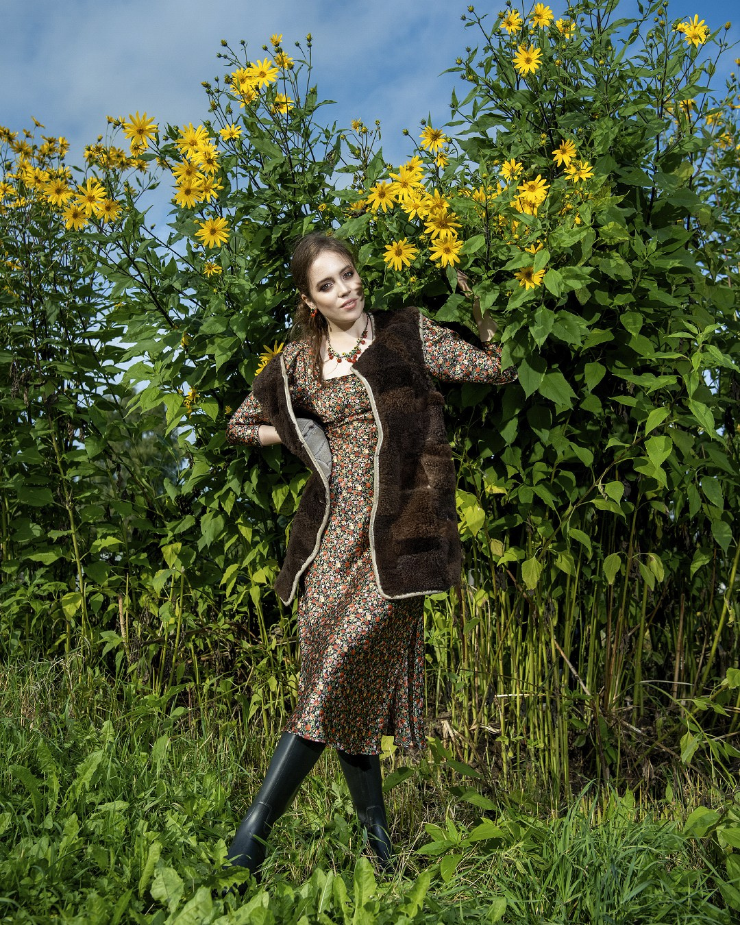 Девушка в цветах и резиновых сапогах в деревне