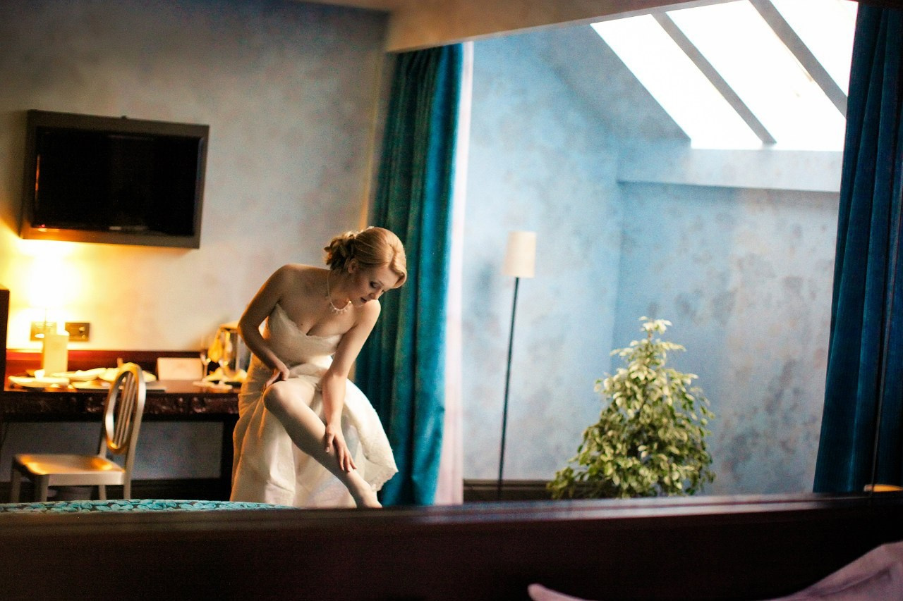 в большом зеркале уютного номера гостиницы отражается как невеста собирается на свадьбу
