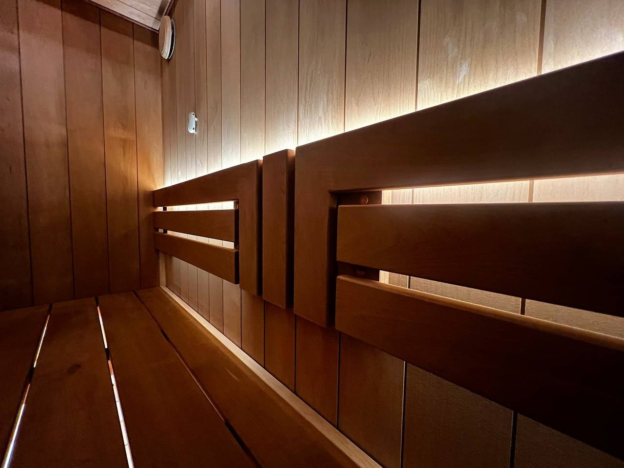 Сауна в Рощино на базе электрокаменки с парогенератором Harvia Virta выполнена из термоольхи с интеграцией световых линий из можжевельника. SaunaTopMasters