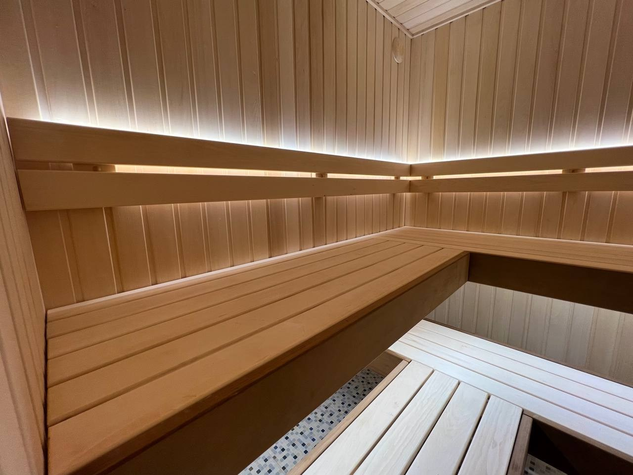 Просторная и светлая сауна в Шаглино выполнена из ароматной липы и африканского абаши, а тепло ей дарит электрокаменка Harvia Trendi KIP. SaunaTopMasters