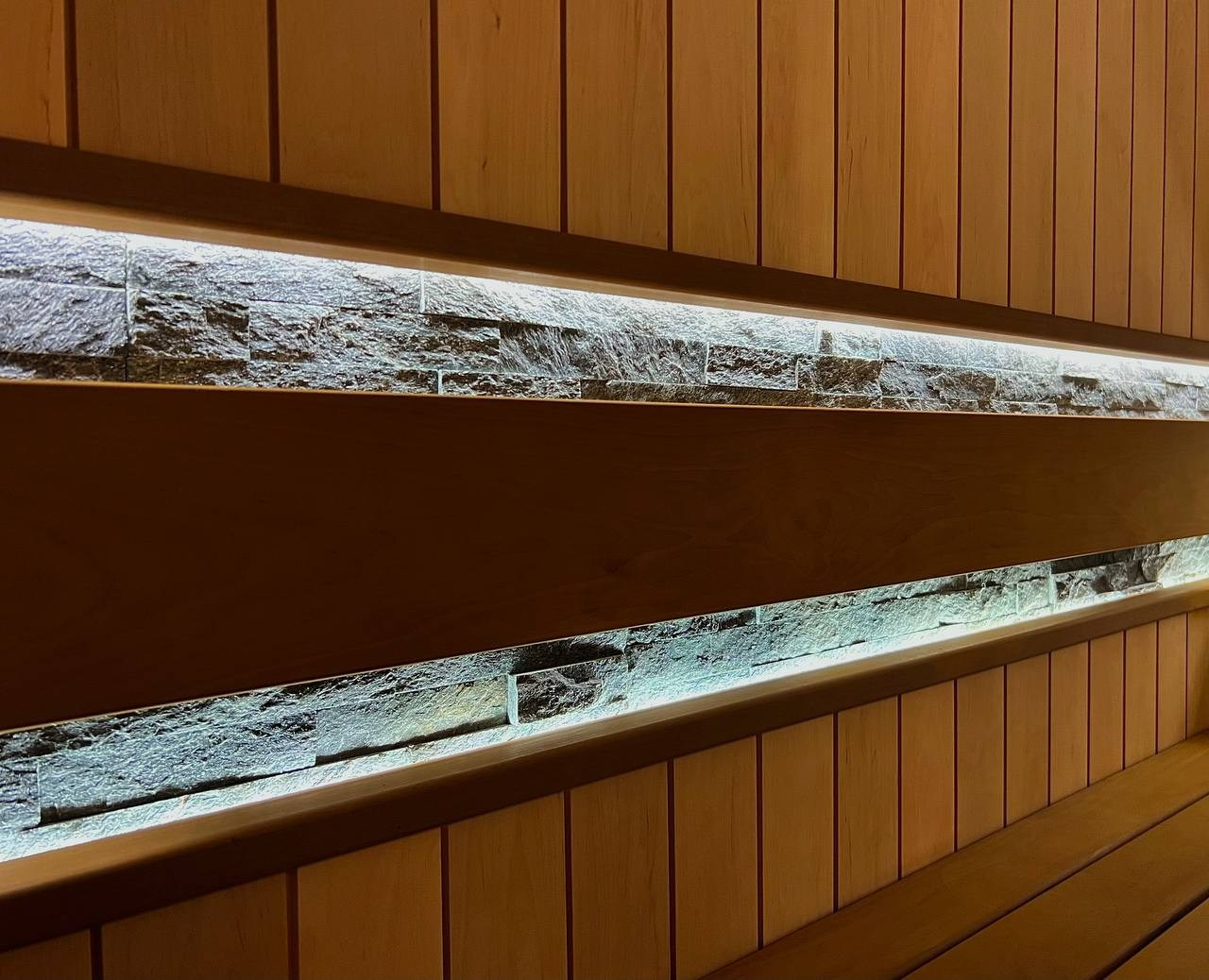 Просторная сауна в Сертолово из термоольхи с интеграцией можжевеловых линий и большого количества натурального камня. SaunaTopMasters