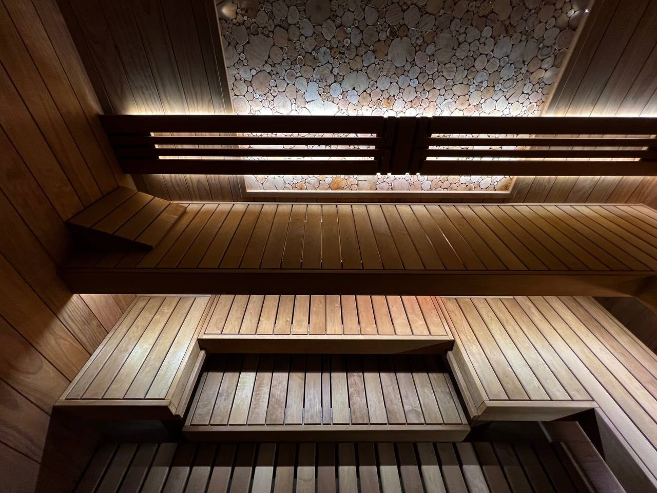 Парная в Небе. Полностью выполнена из термоольхи с интеграцией массивных можжевеловых панно, оптоволокна и подвижных элементов полков. SaunaTopMasters