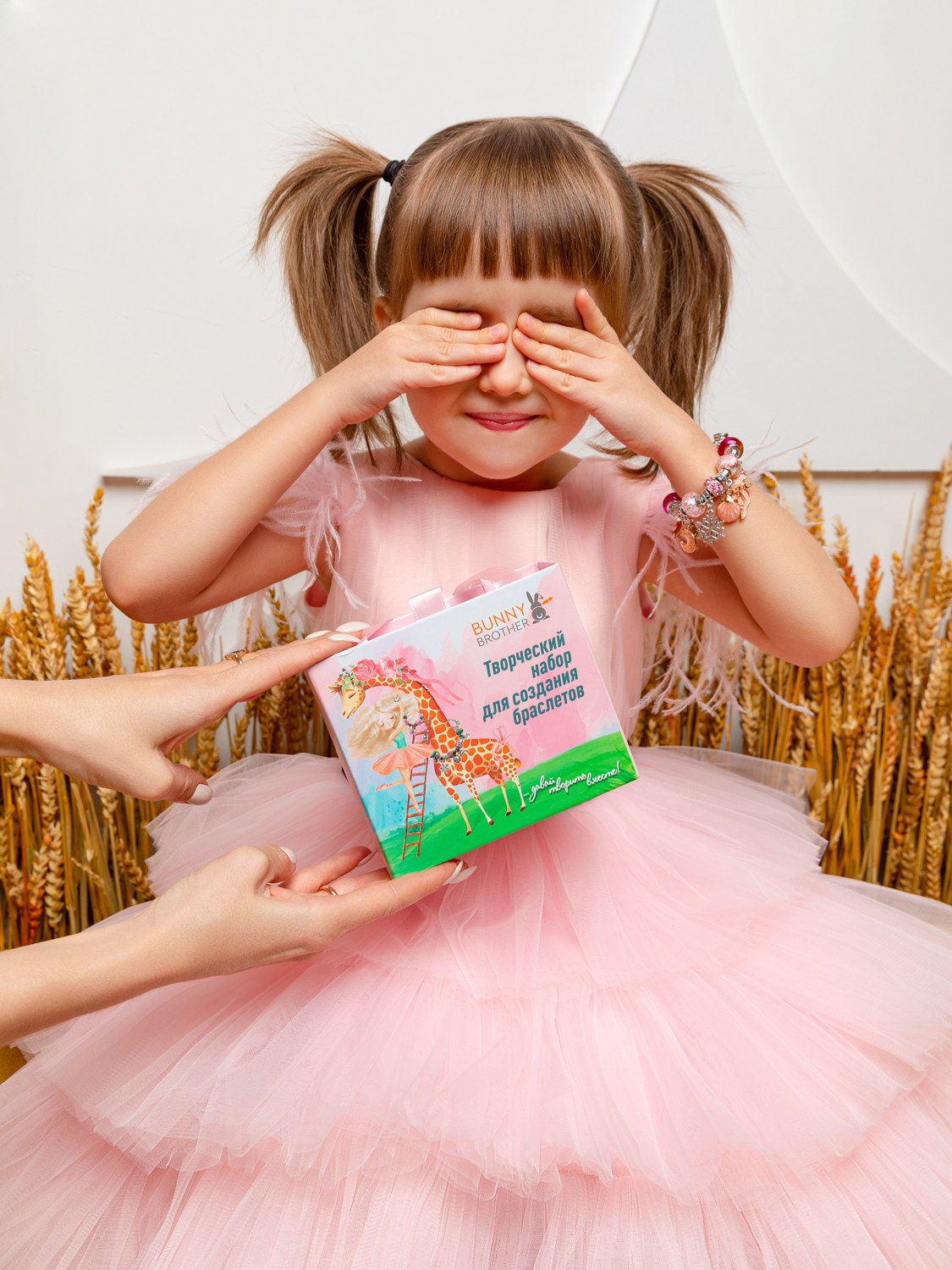 Девочка в розовом платье закрыла глаза в предчувствии подарка.
