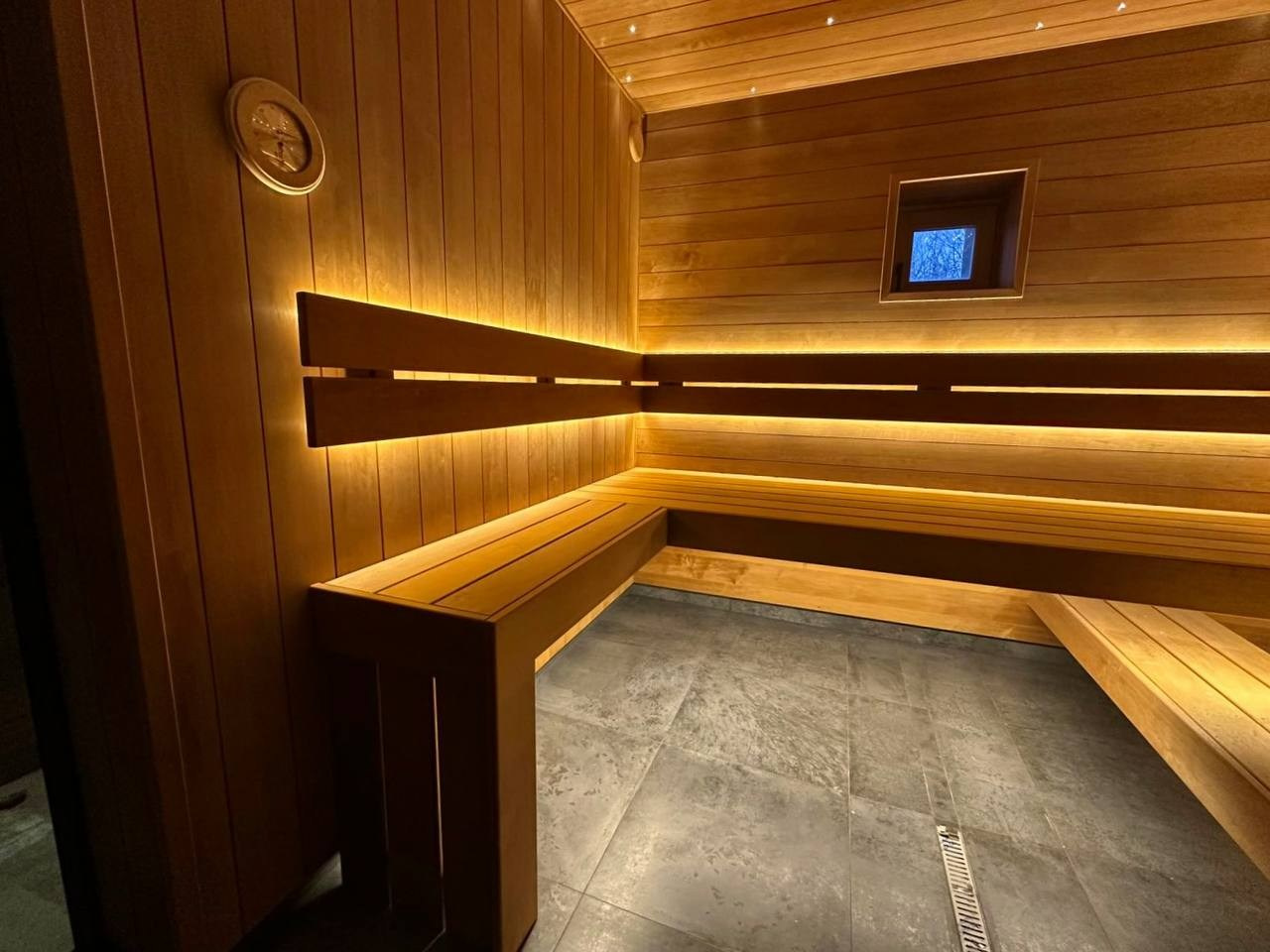 Брутальная парная в Озерках выполнена из термоольхи 135 мм. А среди звездного неба красуется панно из срезов можжевельника. SaunaTopMasters