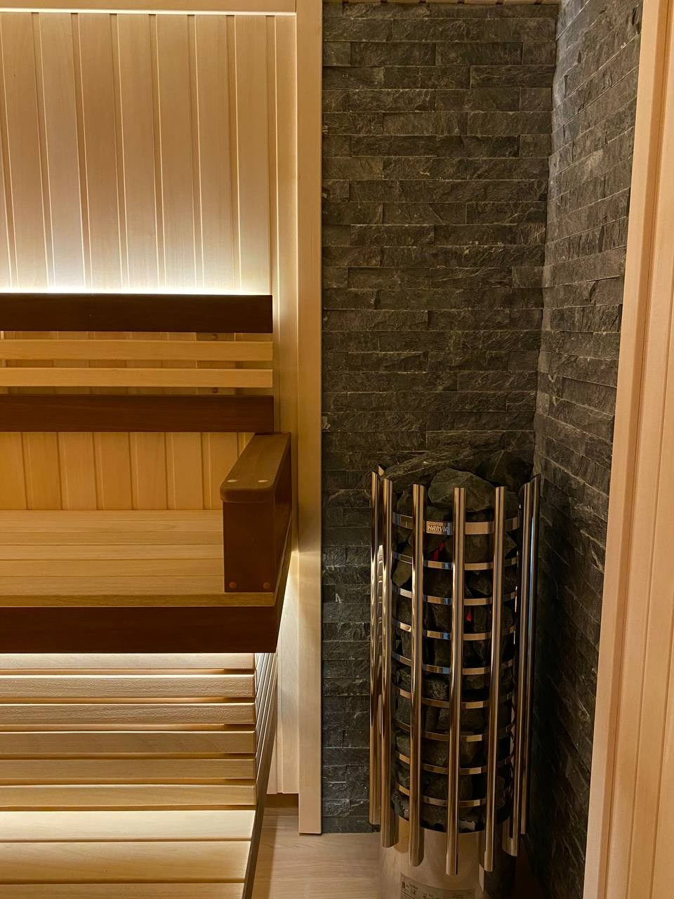 Семейная сауна в Кузьмолово на базе Harvia Glow. В отделку из липы встроены просторные полки из комбинации абаши+ термоабаши. SaunaTopMasters
