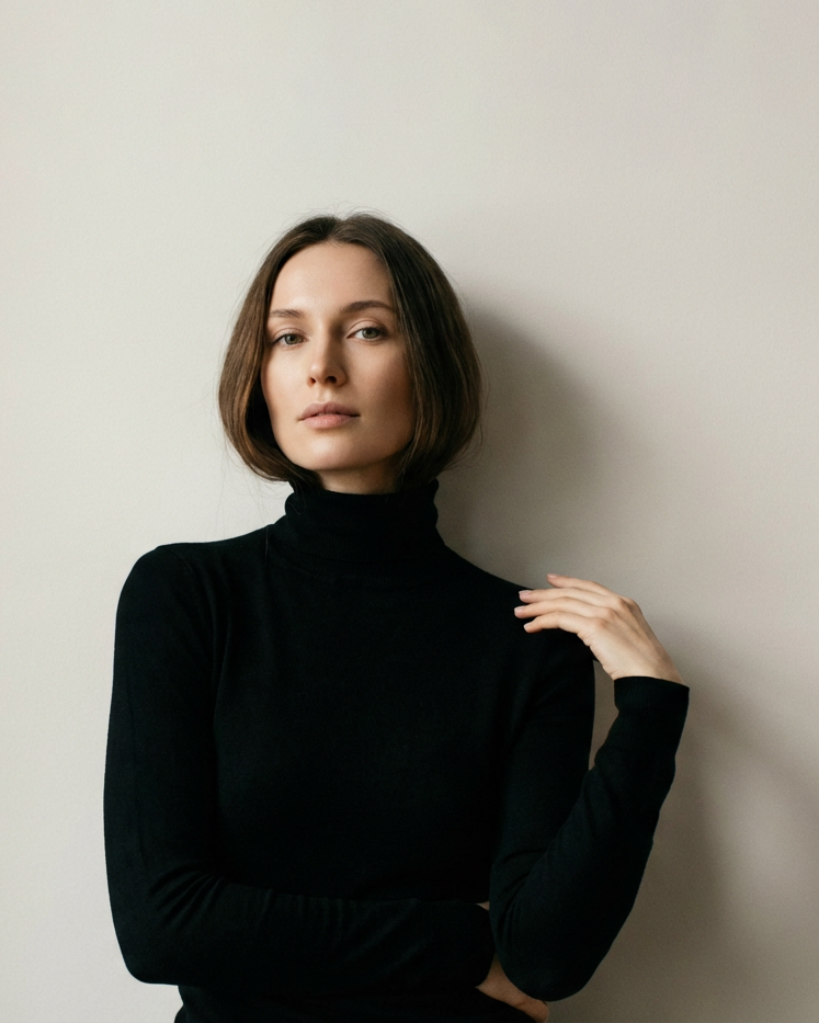 Женский портрет в черной водолазке на монохромном фоне, фотосессия минимализм