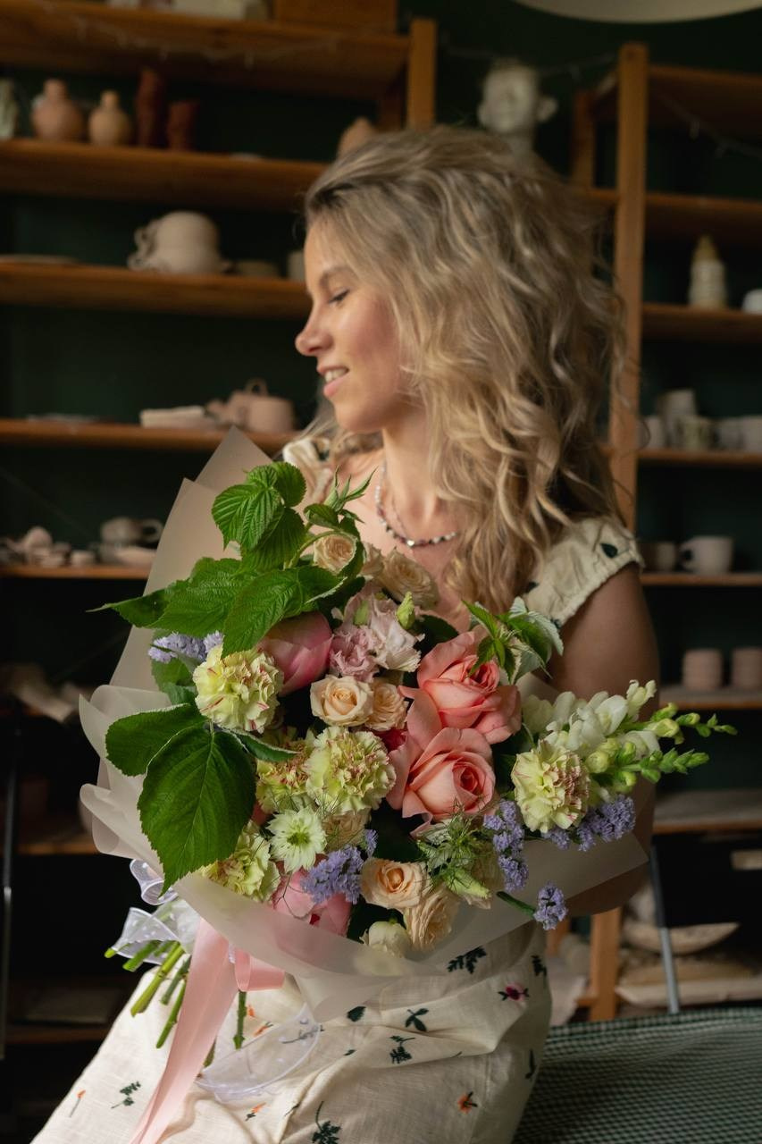 Девушка в гончарной студии с цветами