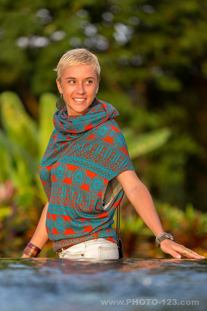Lifestyle travel portrait of a smiling woman outdoors, colorful ethnic clothing, natural light, tropical environment during a fashion and lifestyle photoshoot in Phu Quoc, Vietnam