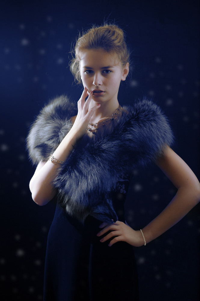 на черном фоне портрет девушки с  горжеткой из черно-бурой лисицы на плечах