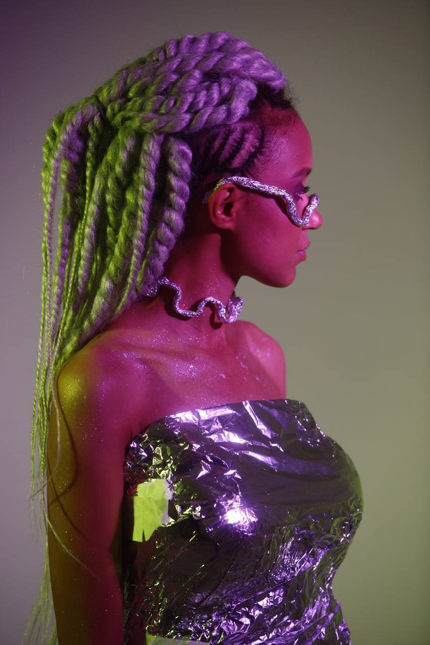 Космическая фотосессия девушки в блестящем наряде с зелёными дредами.