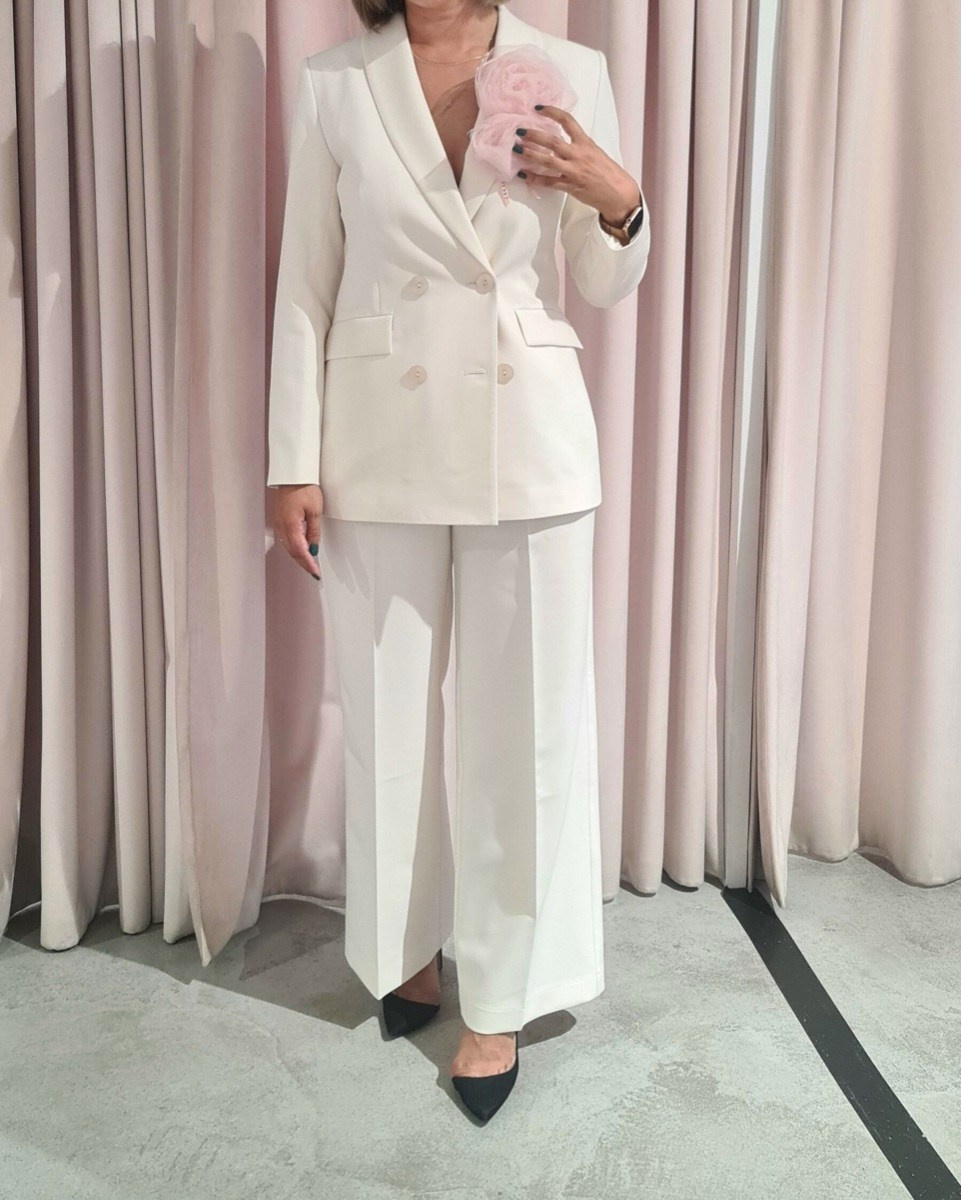 Белый костюм на свадьбу для невесты с цветком