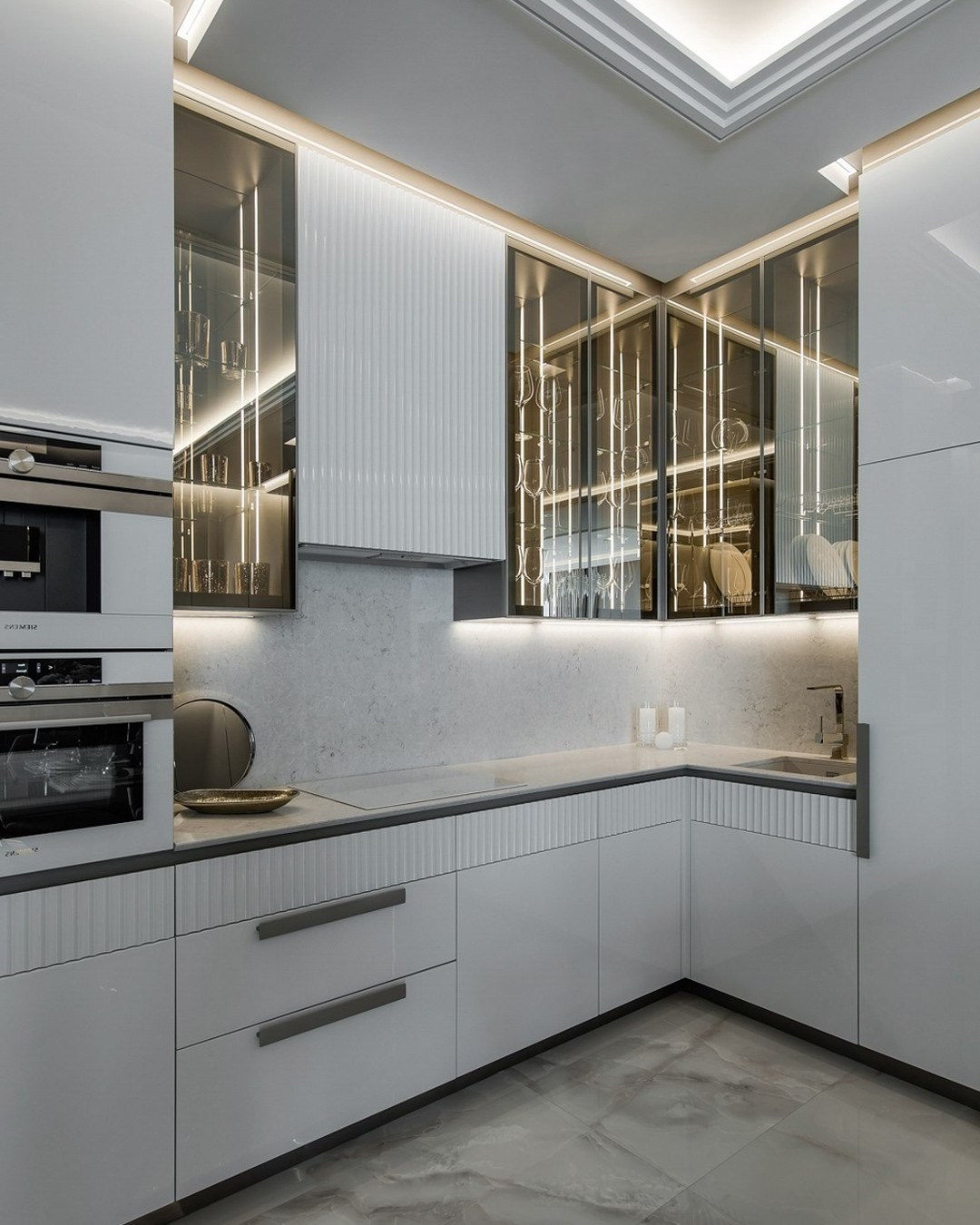 Угловая кухня с белыми фасадами и стеклянными шкафами — дизайн Валерии Котович
