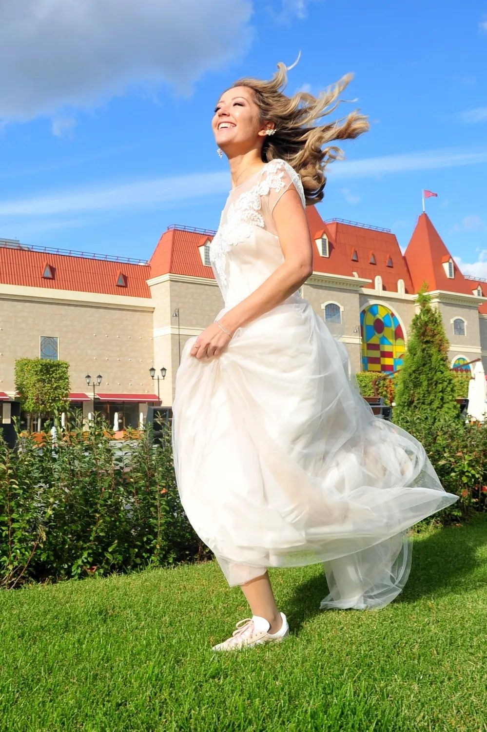 Свадьба на Острове Мечты, невеста бежит по зеленой лужайке на фоне замка