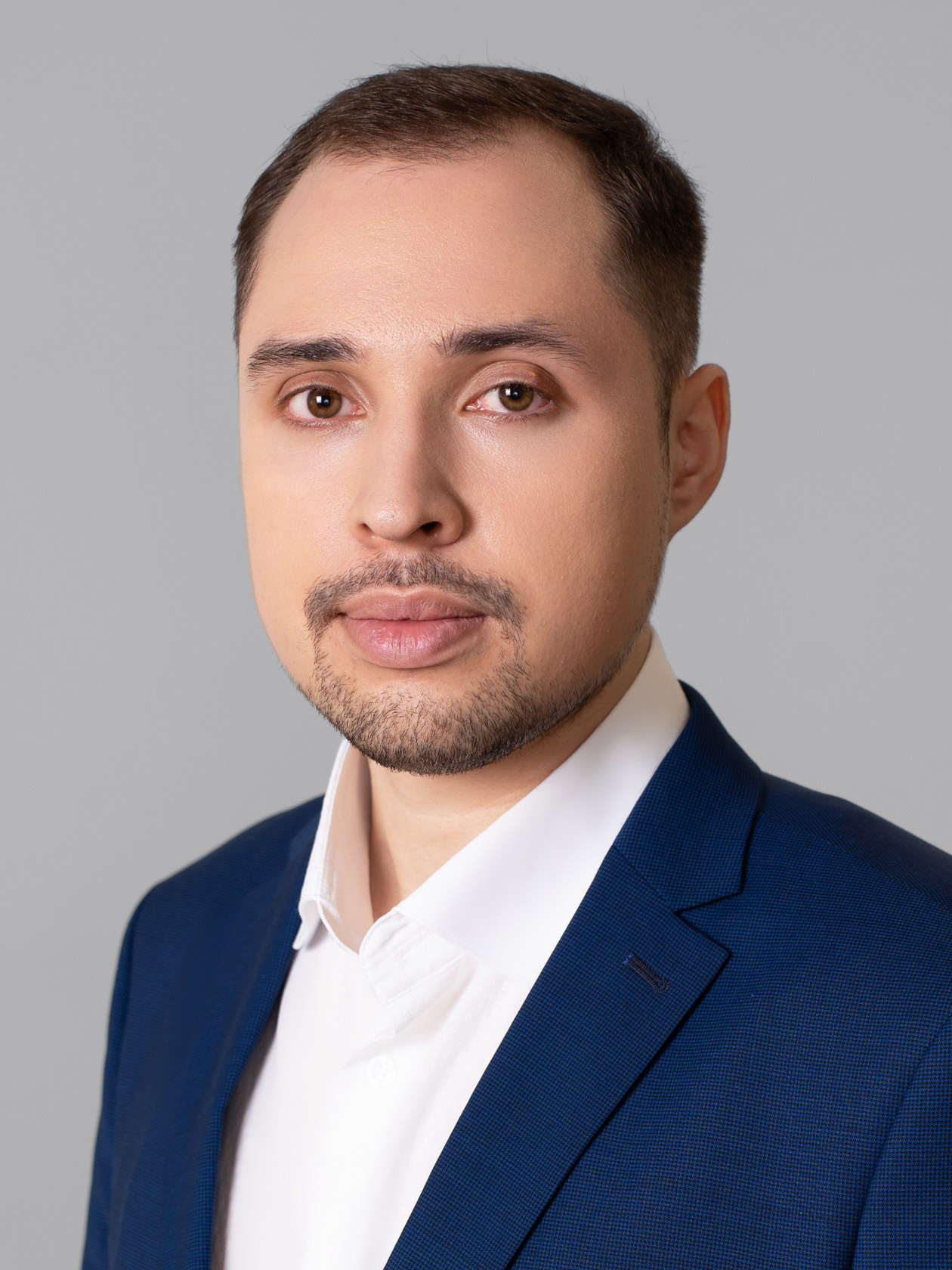 Мужчина в синем пиджаке, деловой портрет по плечи на светлом фоне