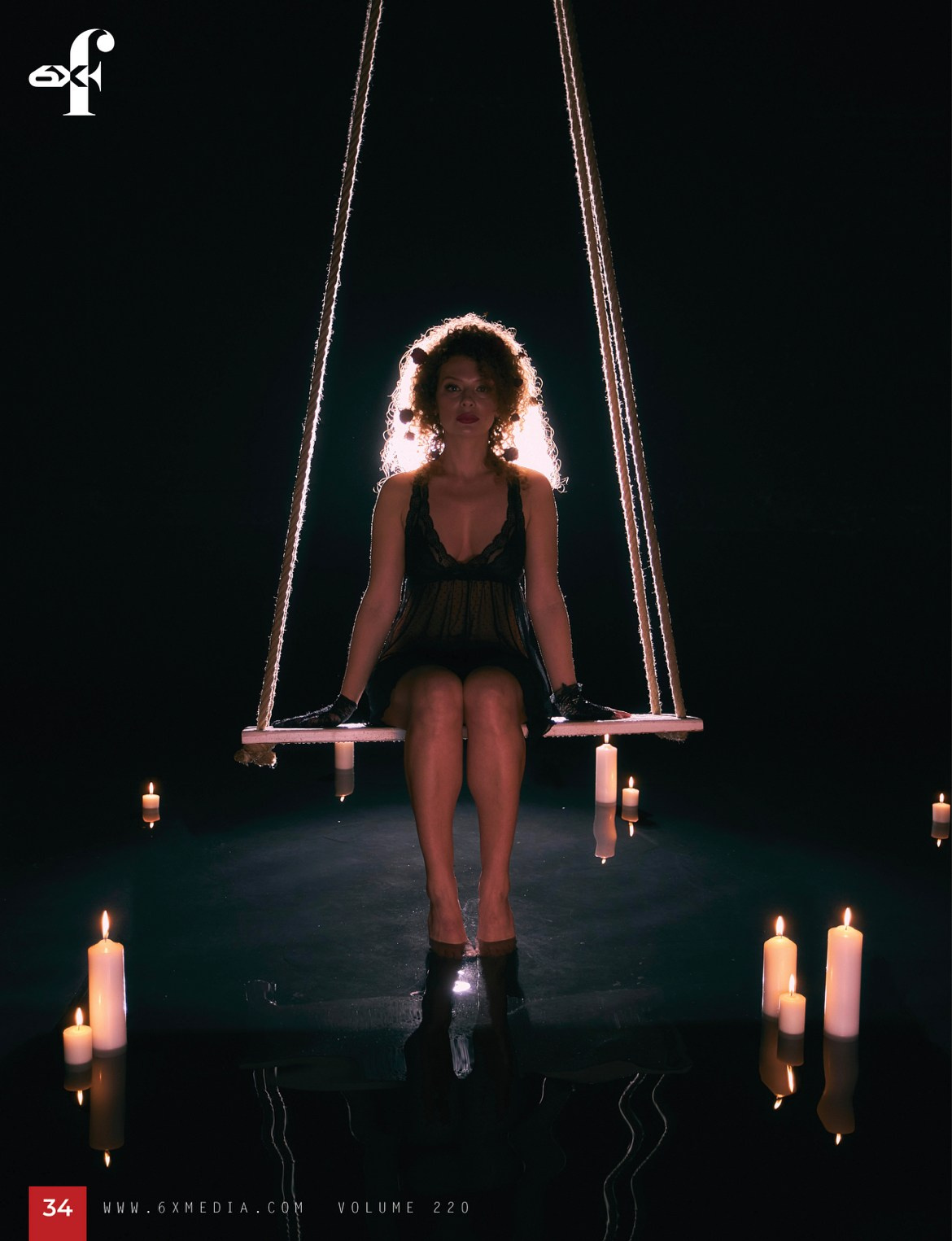 Портрет девушки в черной сорочке с розами в волосах на качелях, качели над водой, а в воде расставлены горящие свечи