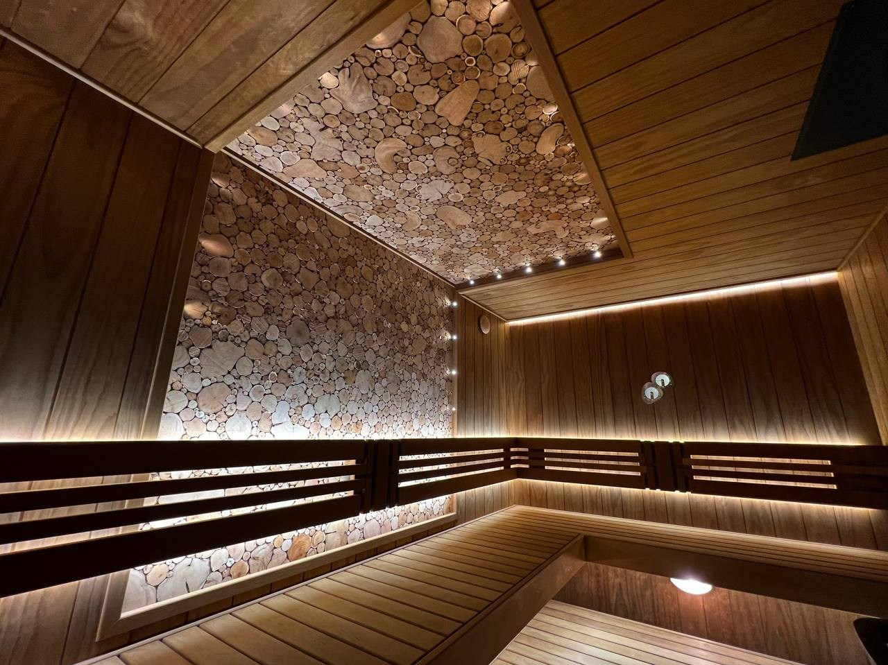 Парная в Небе. Полностью выполнена из термоольхи с интеграцией массивных можжевеловых панно, оптоволокна и подвижных элементов полков. SaunaTopMasters