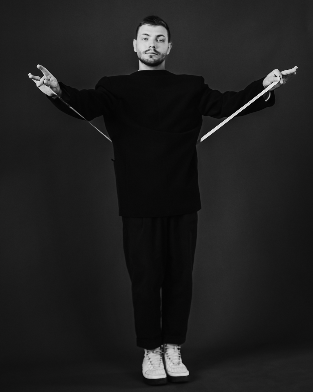 Креативная идея в съемке мужского портрета в полный рост с метром в руках