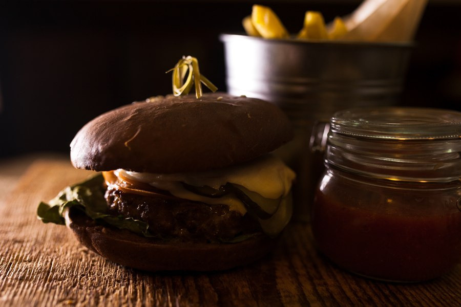 Фотография меню и блюд. Фуд-фотография бургера гамбургера в низком темном ключе.