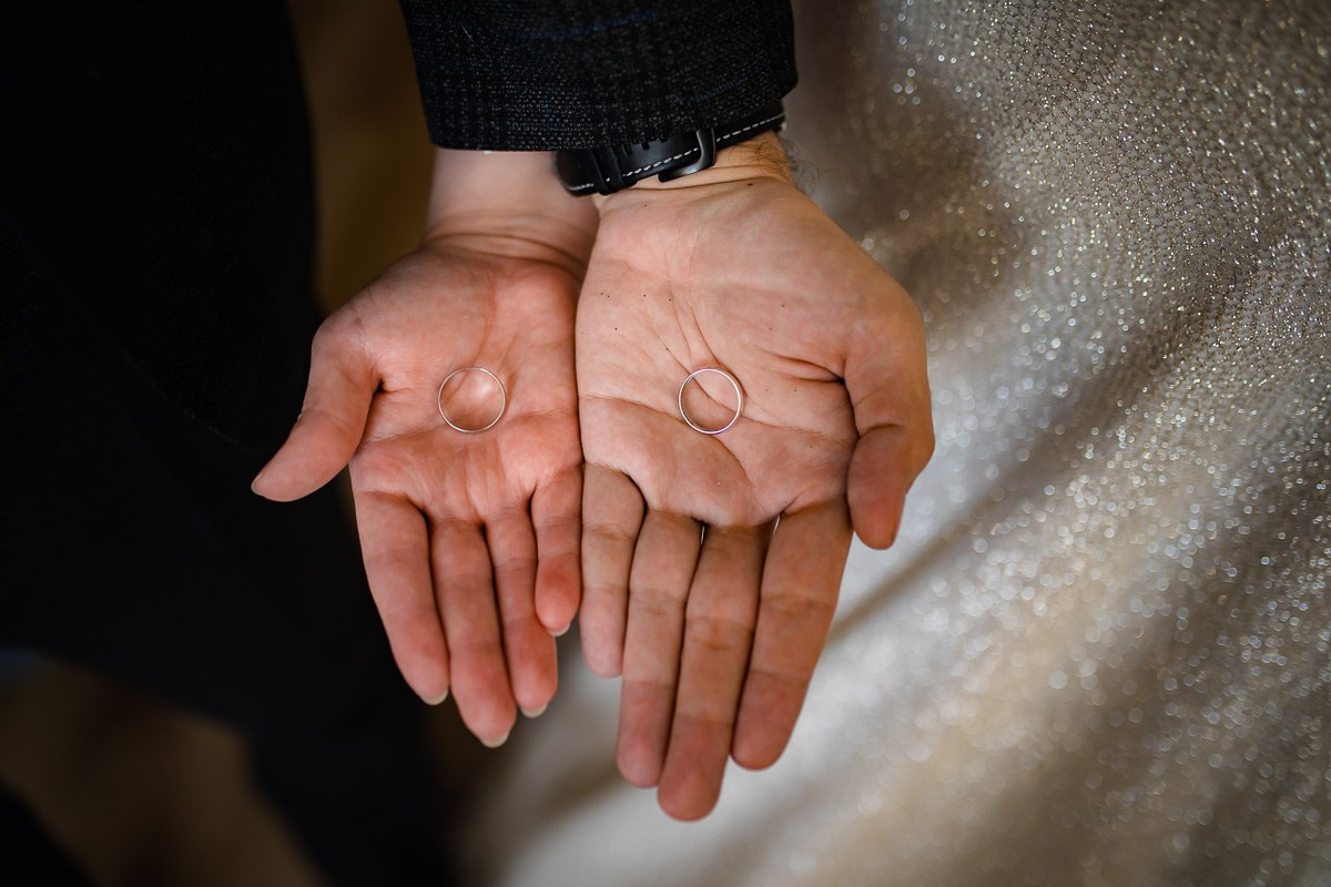 На ладонях молодожёнов кольца крупным планом