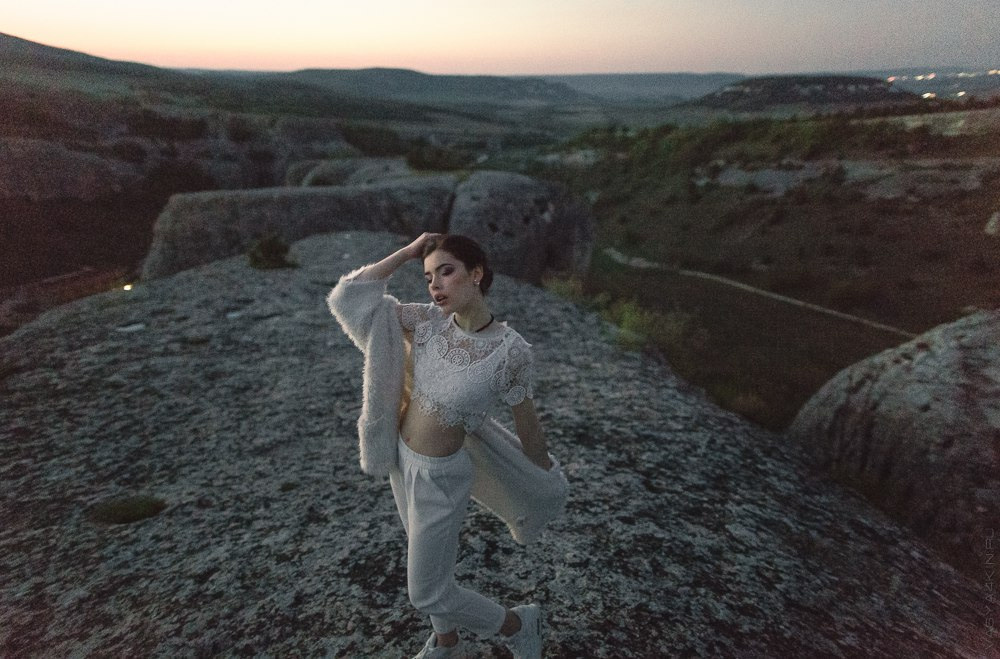 Молодой и невеста, стоящие на вершине горы, окруженные облачным океаном, создающие атмосферу свободы и счастья