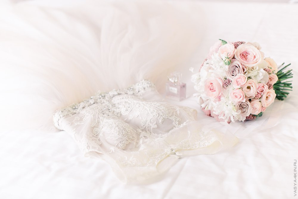 Новобрачные сидят на шезлонге около бассейна, окруженного факелами и цветами, словно они покоряют новые горизонты