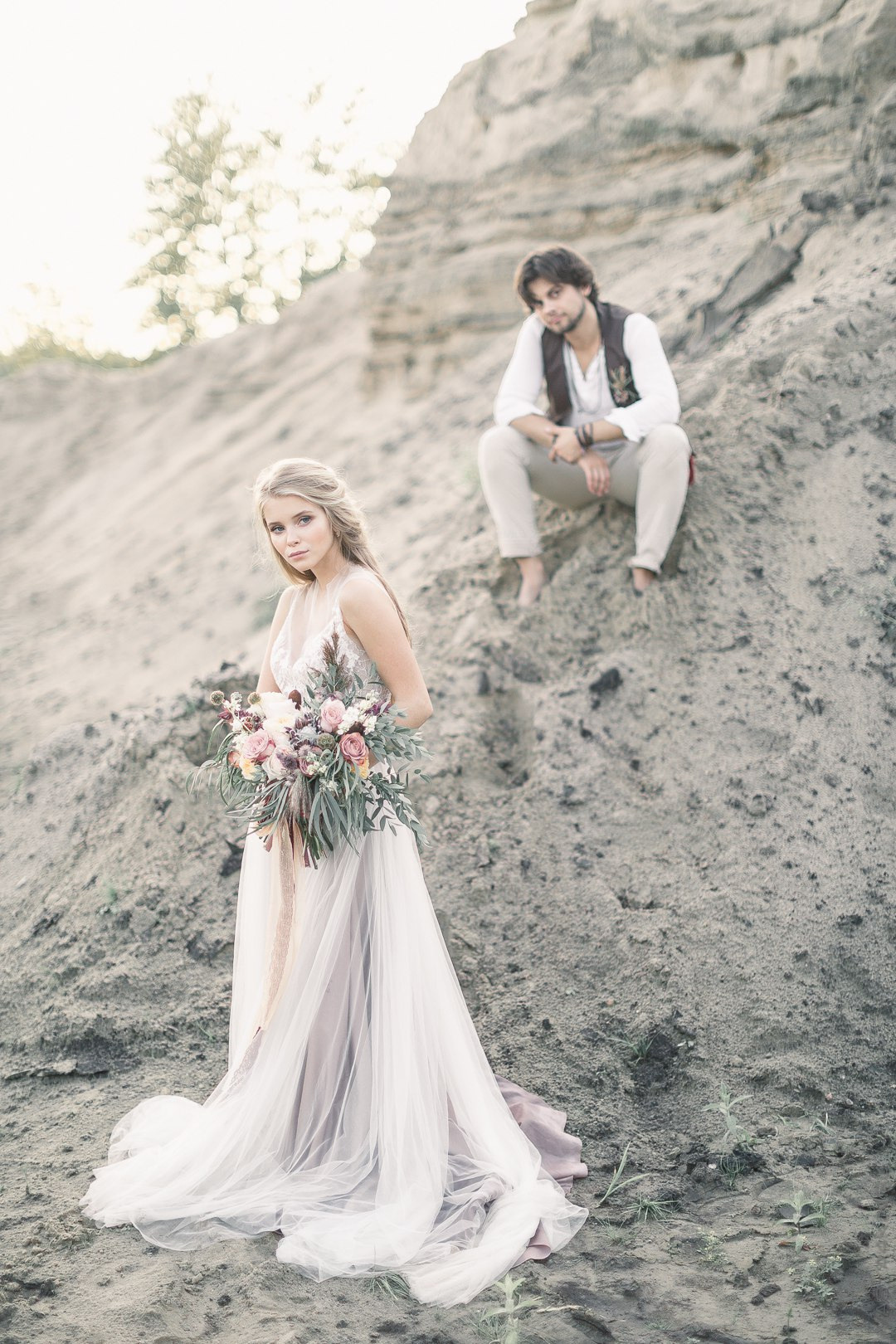 Пара стоит под расцветшими деревьями, на фоне ярких цветов, словно они находятся в мире сказки на этой уникальной свадебной фотографии