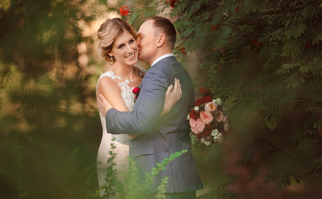 Свадебная фотография с невестой, сидящей на коленях у жениха, закрывая ему глаза, что создает ощущение тайны и сюрприза