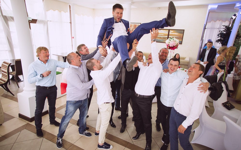 Невеста и жених рисуют купол вокруг себя на фото и смеются, словно они создают свой личный рай