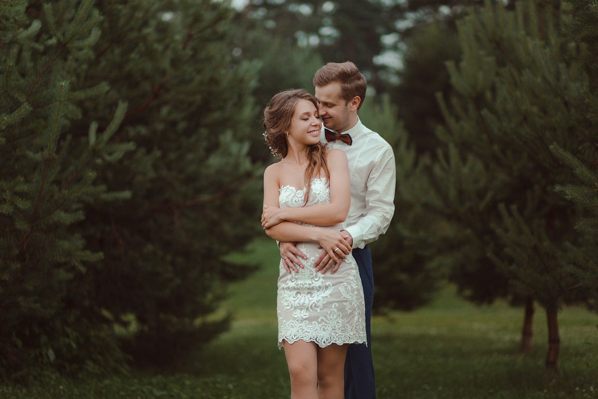 Невеста, стоящая рядом с украшенным автомобилем, ждущим их путешествие в мир счастливых дней