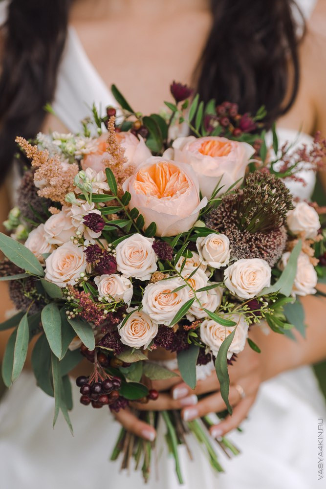 Новобрачные обнимаются на фоне заходящего солнца, создавая идеальное романтическое настроение