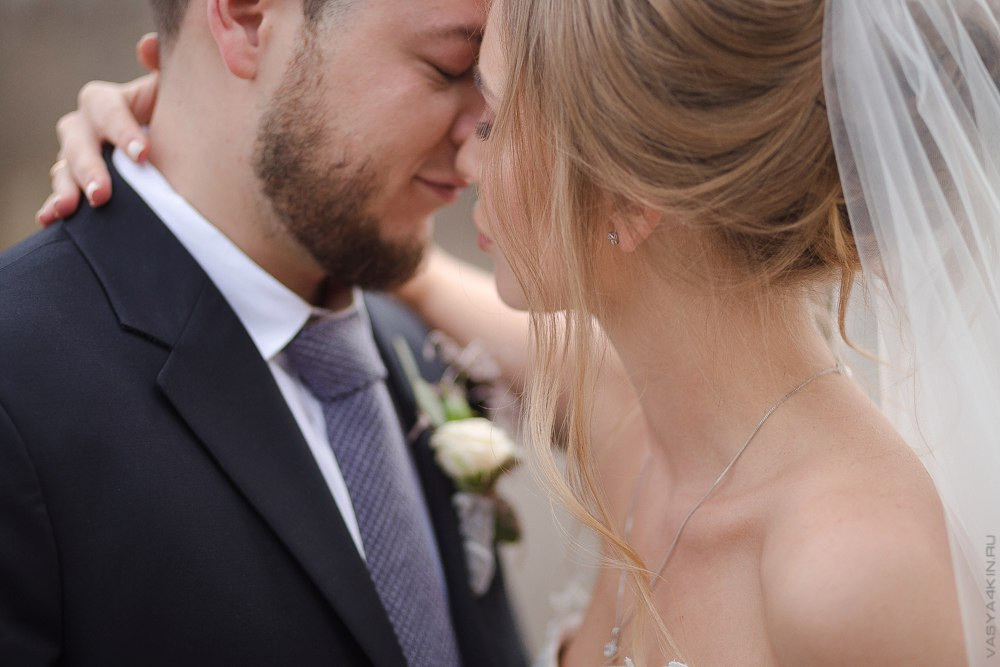 Пара целуется на фоне заката, словно их страсть становится небесной на этой прекрасной свадебной фотографии