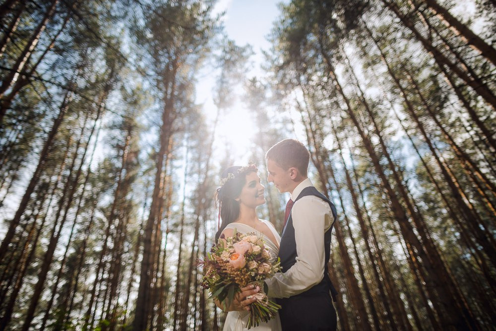 Поженившиеся влюбленные, улыбающиеся и притянутые друг к другу на берегу океана