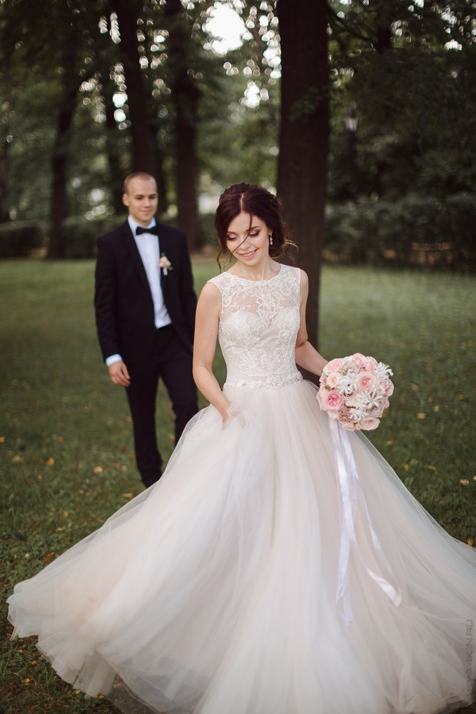 Невеста и жених прогуливаются по дороге, украшенной светящимися шарами, на своей дорогой свадьбе в Ярославле