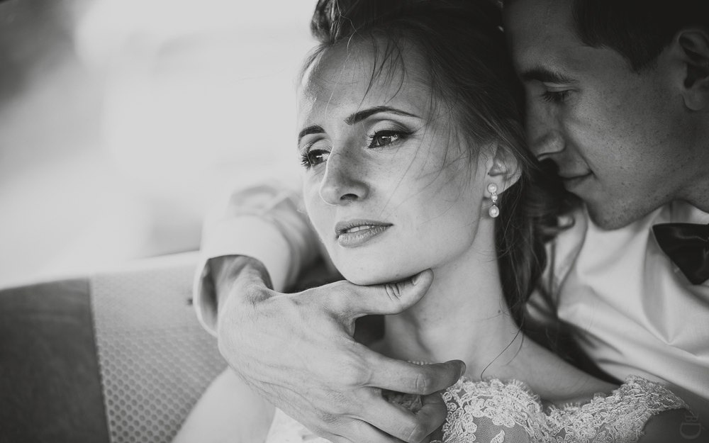 Свадебная фотография молодых, обнимающихся перед зарубежной виллой