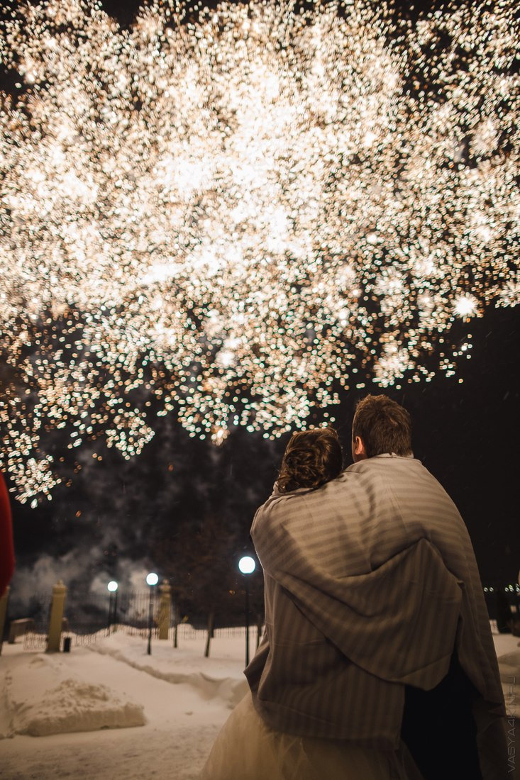 Молодожены на фоне дворца в Ярославле, идущие по дороге, усыпанной лепестками цветов, в их руках фонарики