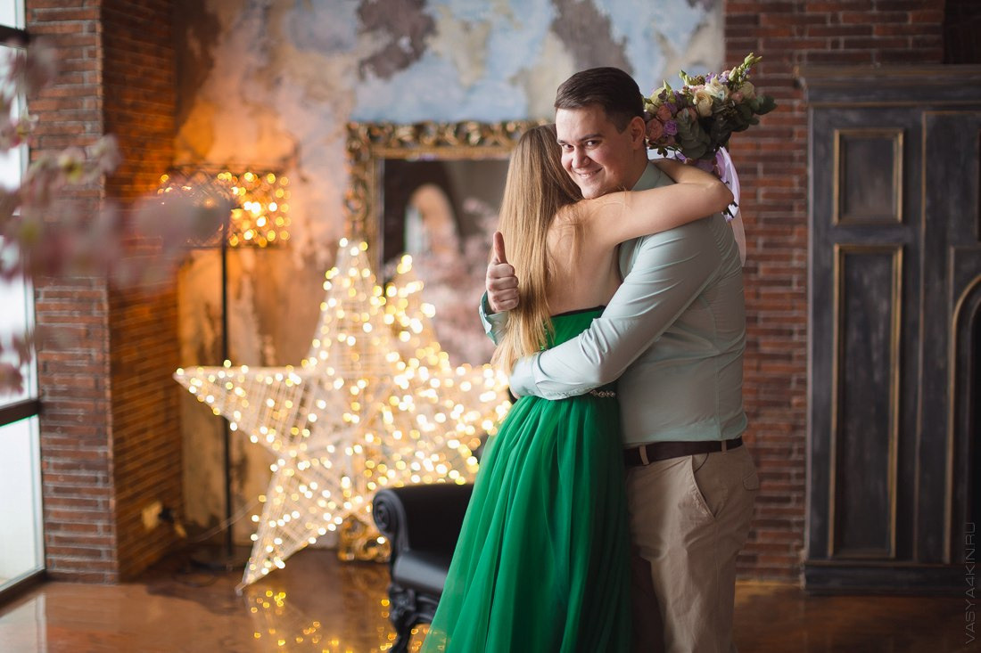 Молодожены сидят на лугу, окруженном цветами